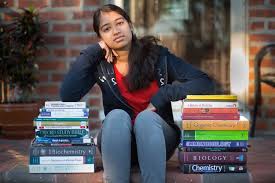 Student with a couple stacks of textbooks